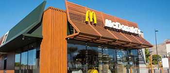 Mcdonalds zgrada s plavim nebom i logotipom ispred zgrade 