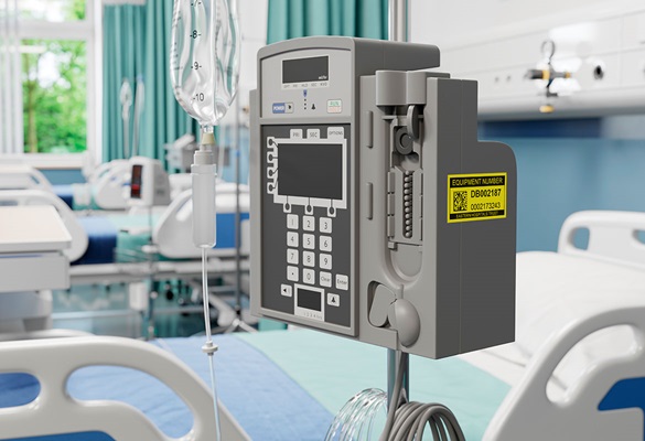 Žuta naljepnica za održavanje na pumpi za infuziju pored kreveta u bolničkom odjelu 