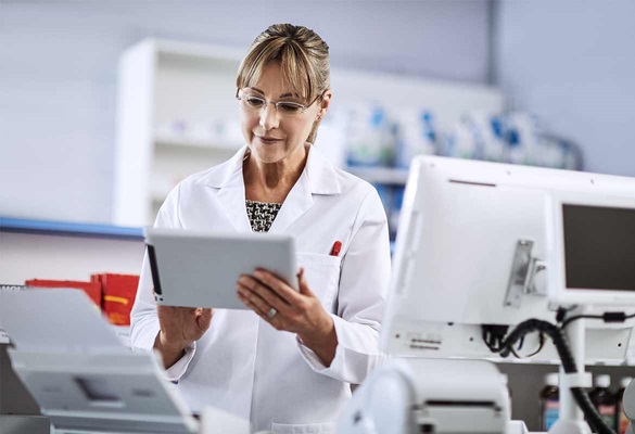 Farmaceutkinja u bijeloj uniformi koristi tablet