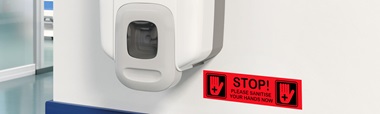 Black on red Brother P-touch TZe label on hand sanitising unit